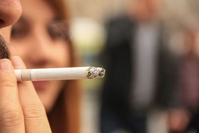 Close-up of hand holding cigarette