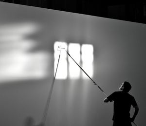 Silhouette man standing against wall