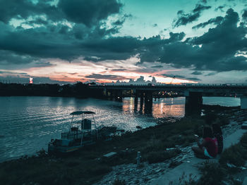 Bridge over river against sky during sunset