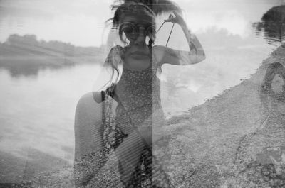 Digital composite image of woman standing by lake