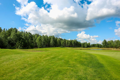 Scenic view of golf course against sky