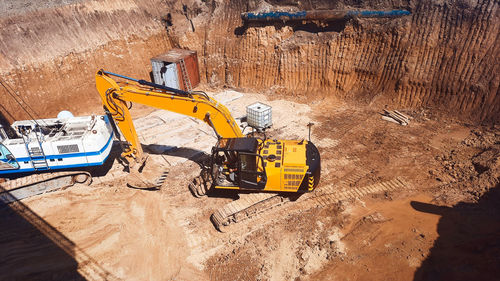 Excavator in the pit laying tunnel, road works