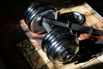 Close-up of dumbbell and barbell on carpet