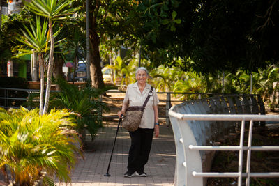 Senior woman at the ronda del sinu walking path along the river bank in the city of monteria