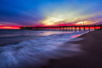 Pier over sea against sky during sunset