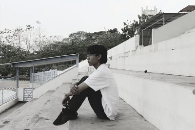 Full length of boy sitting on railing