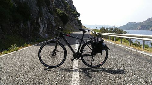 Bicycle on mountain road against sky