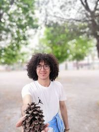 Portrait of young woman standing against plants