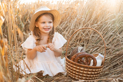 Portrait of young woman sitting on wicker basket