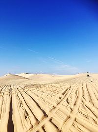 Scenic view of desert against clear blue sky