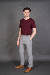 Young man standing against black background