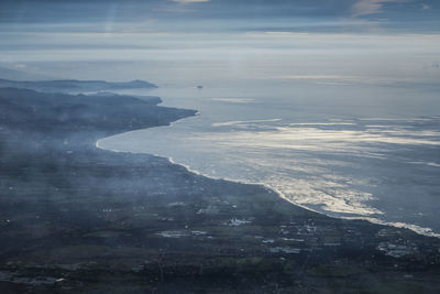 Scenic view of sea and mountains against sky