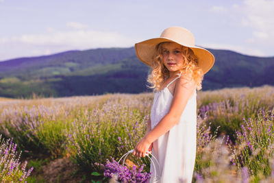 Portrait of girl standing amidst flowering field