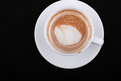 Directly above shot of coffee on table against black background