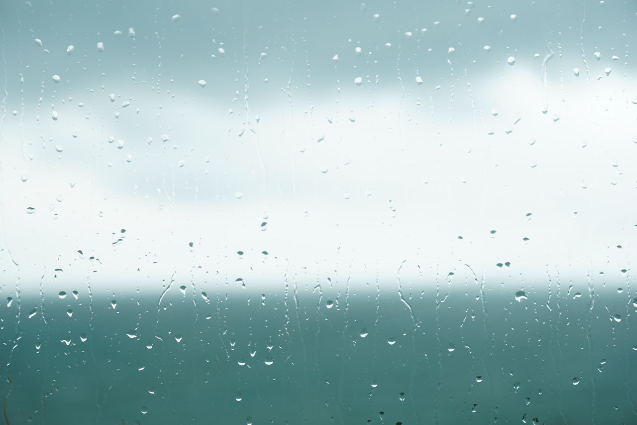 FULL FRAME SHOT OF WET GLASS WINDOW IN RAINY SEASON