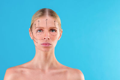 Portrait of a young woman against blue background