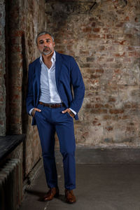 Portrait of young man standing against wall