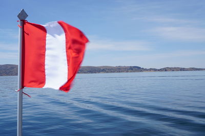 Close-up of flag in sea against sky