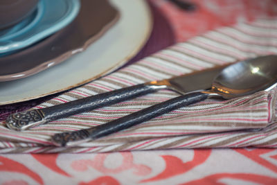 Close-up of silverware on napkin at dining table