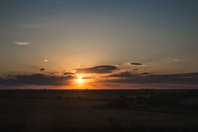 Scenic view of silhouette field against sky during sunset