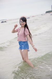 Woman standing on beach against sea