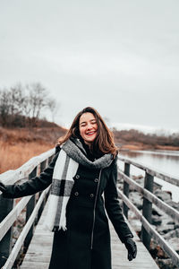 Woman standing in snow against sky during winter