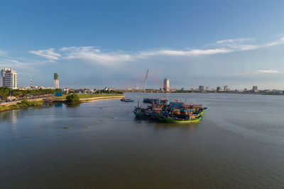 Boats in sea against buildings in city