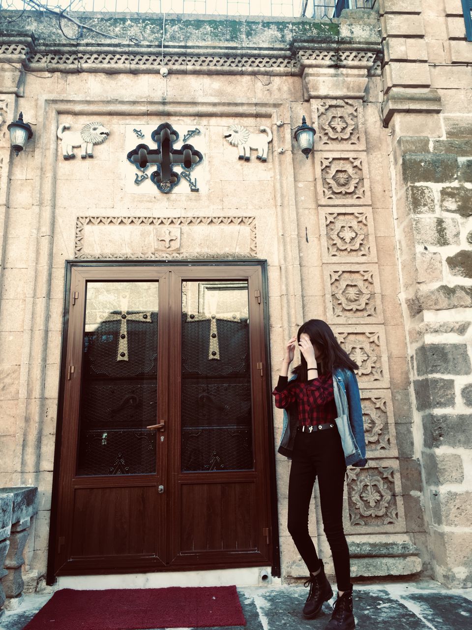 WOMAN STANDING BY DOOR OF BUILDING