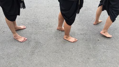 Low section of friends standing on road