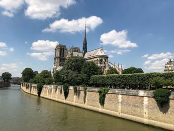 Traditional building by river against sky