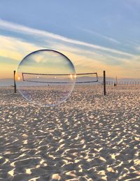 Close-up of beach against sky during sunset