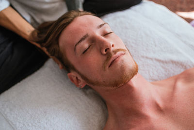 Portrait of shirtless man sleeping on bed