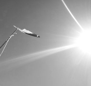 Low angle view of sun shining through clouds