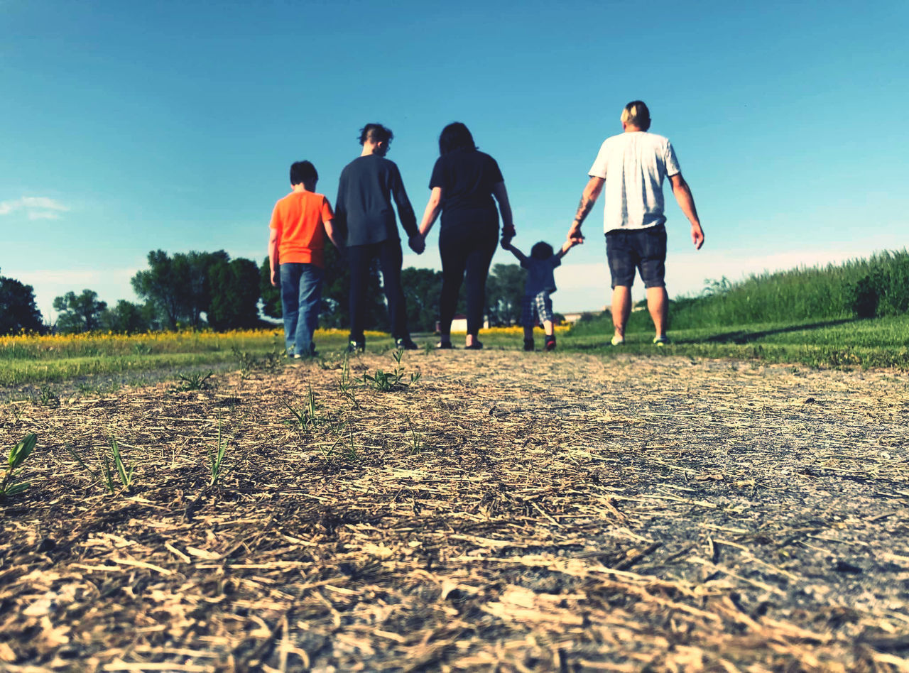 GROUP OF PEOPLE WALKING ON FIELD