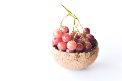 Close-up of grapes in bowl against white background