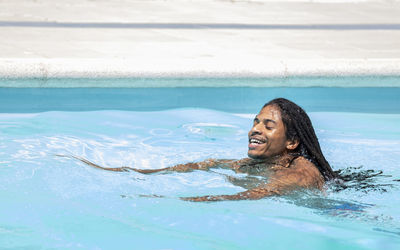 Portrait of young woman swimming in pool