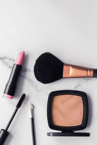 High angle view of make-up brushes against white background