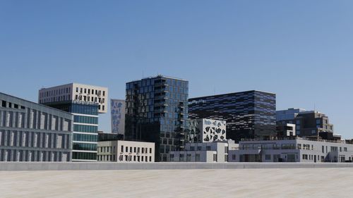 Low angle view of buildings against clear blue sky