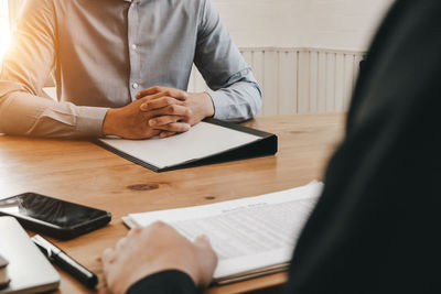 Midsection of man sitting on table