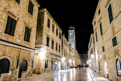 Street amidst buildings in city at night