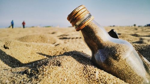 Close-up of bottle on beach