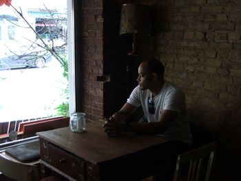 Portrait of young woman sitting on wall