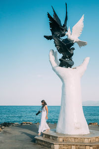 Rear view of woman standing at beach