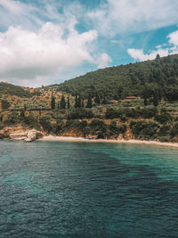 Scenic view of sea and mountains against sky