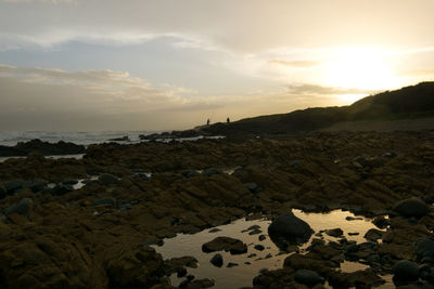 Scenic view of rocks against sky during sunset