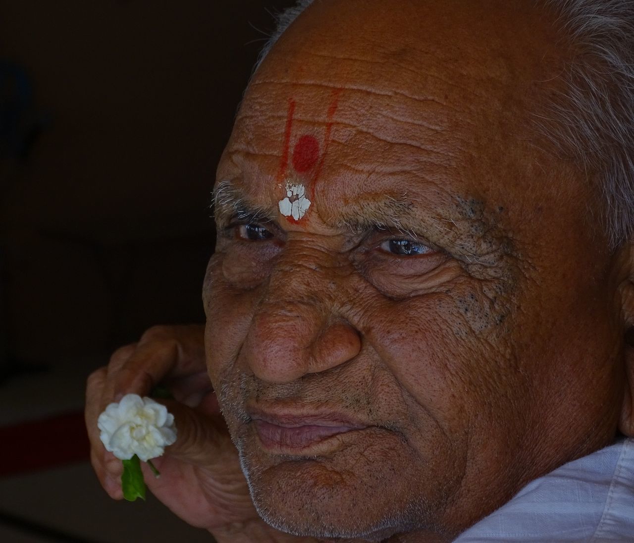 CLOSE-UP PORTRAIT OF MAN WITH FLOWERS IN HAIR