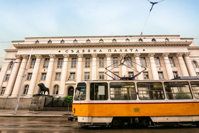 Train on railroad track in city against sky