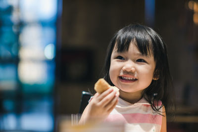Cheerful girl holding food while looking away