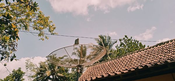 Low angle view of trees and building against sky