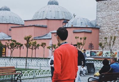 Rear view of people standing in city